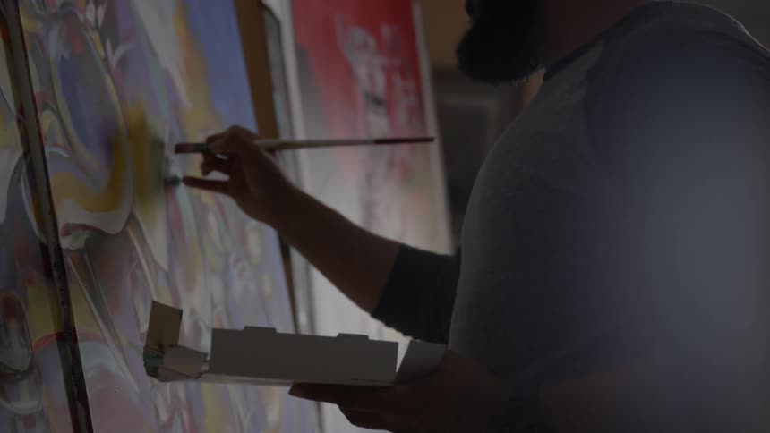 A man paints on a canvas