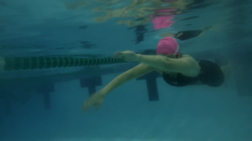 A woman dives swimming into the pool