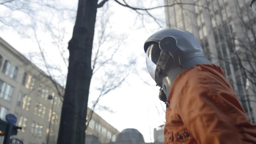 Man wearing a helmet walks through a city