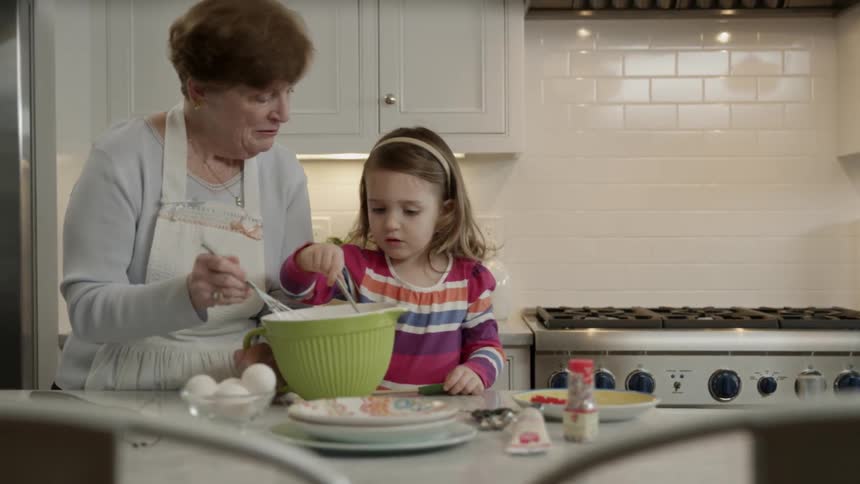 A woman and girl stirs a bowl