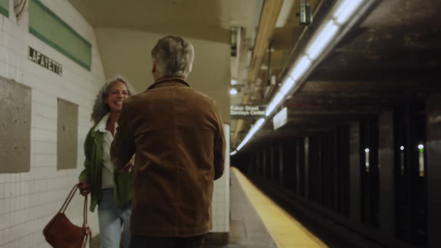 A man and woman dancing on a train station