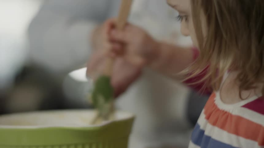 Child stirs batter with a spatula