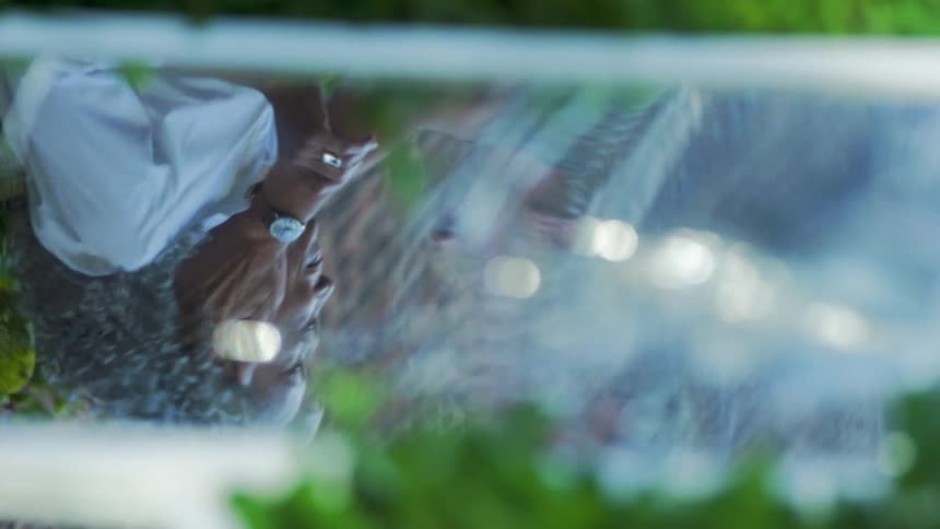 The reflection of the face of a woman with curly white hair who is happily conversing with someone