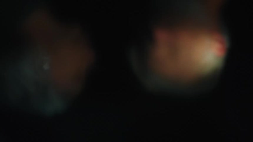 A reflection of a man and woman can be seen in rippling water