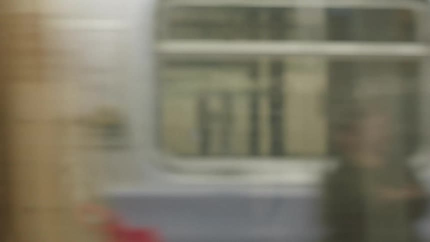 A subway car pulls into a station platform labeled lafayette on the wall behind the tracks a couple standing on the platform is briefly captured in the trains doorway as the car comes to a stop