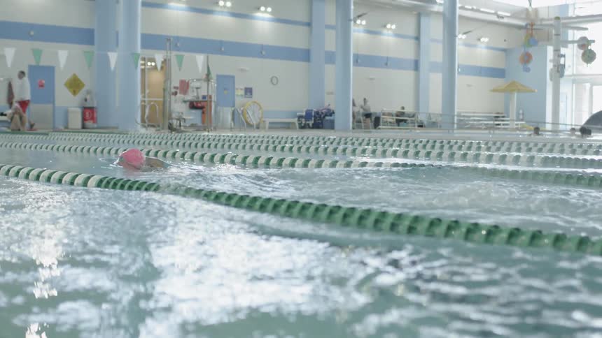 Swimmer about to dive into a large pool in her lane