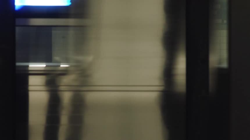 A man and woman standing on a subway station platform