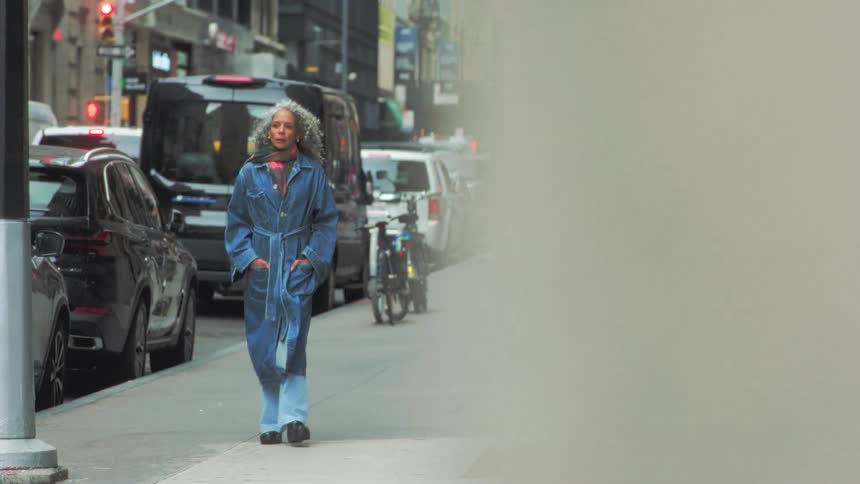 A group of people walking down a sidewalk