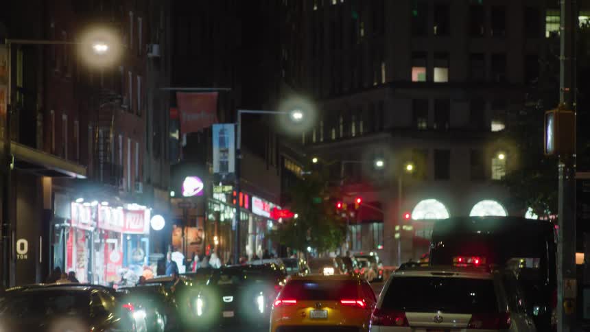 A view of some traffic driving around in a city with tall buildings