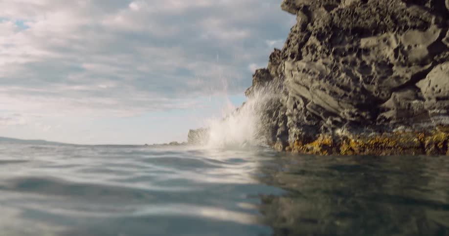 A man doing a backflip off a rock into the ocean