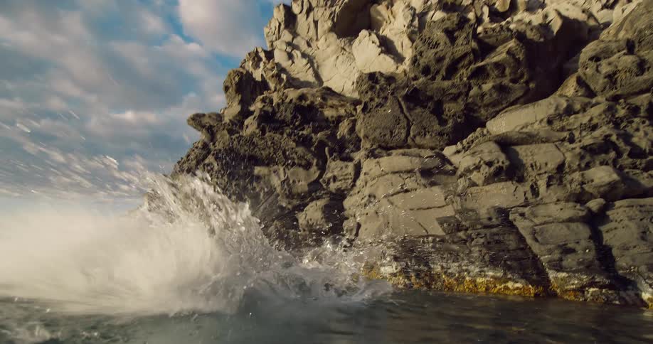 The man dives off the rocks into the water