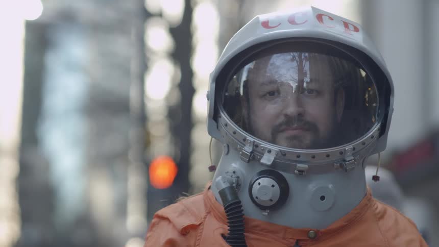 Man wearing a helmet walks through a city