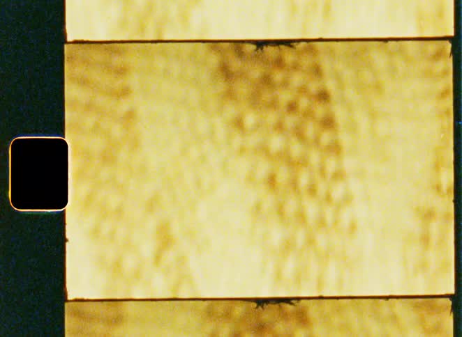 A rectangular sepiatoned material with vertical diagonal shadowlike streaks runs across its surface resembling aged or damaged film stock