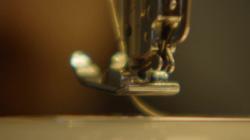 A closeup of the presser foot of an electric sewing machine