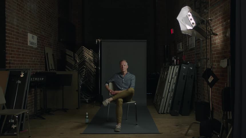 Man sits in a chair in a studio
