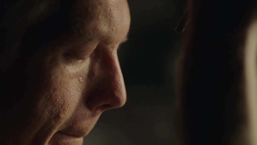 A man looks down and sadly nods his head before looking back up