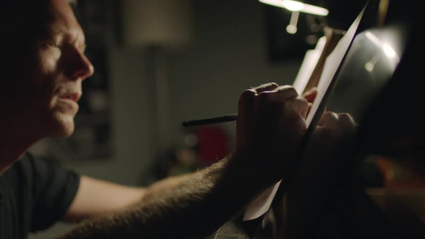 Man writes on a piece of paper in the dark