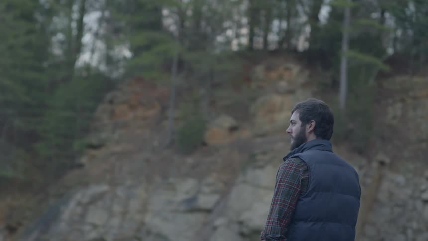 Man standing still and observing the surroundings in forest wilderness