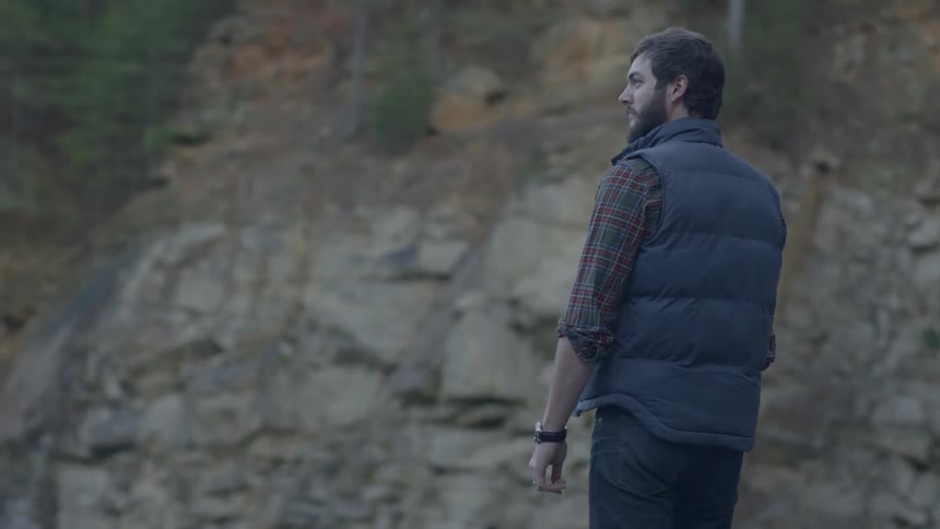 Man standing still and staring out in the wilderness