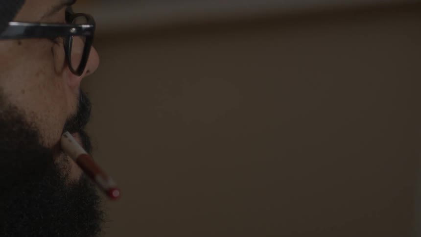 A man is holding a pen in his mouth