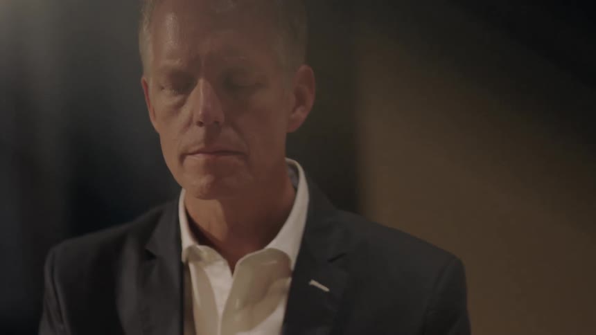 A man in a suit waiting in a room for something