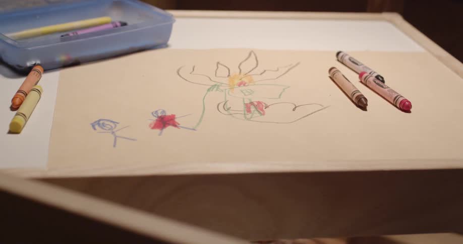 A child's drawing on a desk with crayons