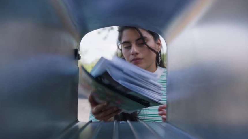 Woman retrieving letters from mailbox