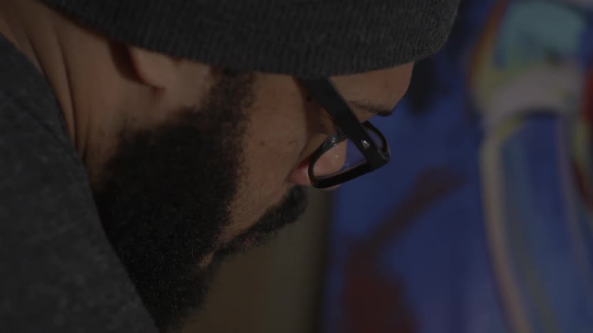 A man wearing glasses is looking down