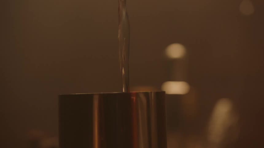 A person mixing a drink in a room