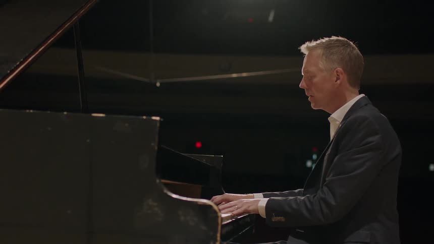 A man playing the piano on a stage