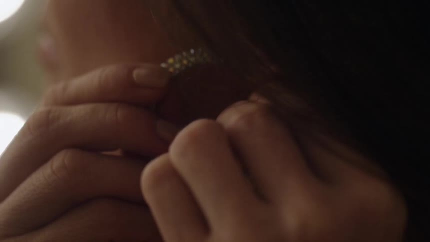 Woman putting earring in her ear