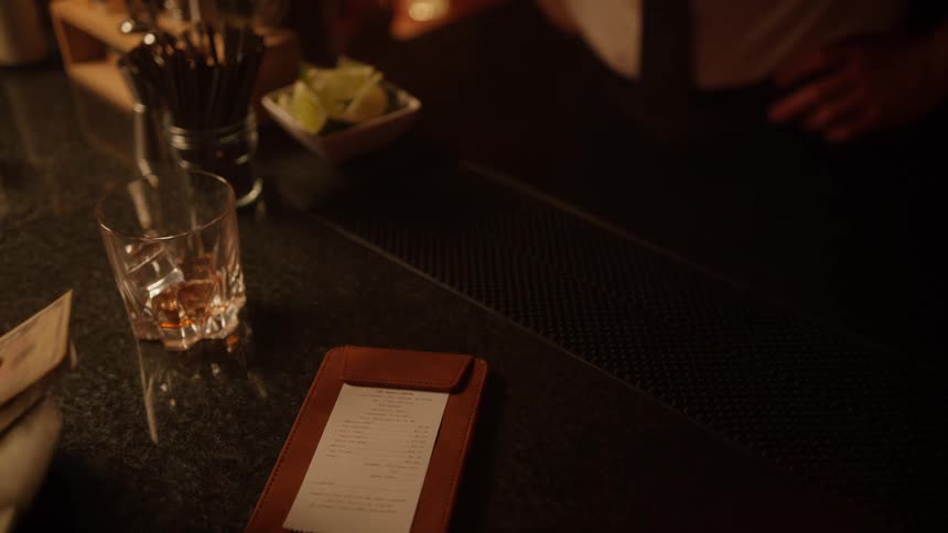 Person paying with dollars at a bar