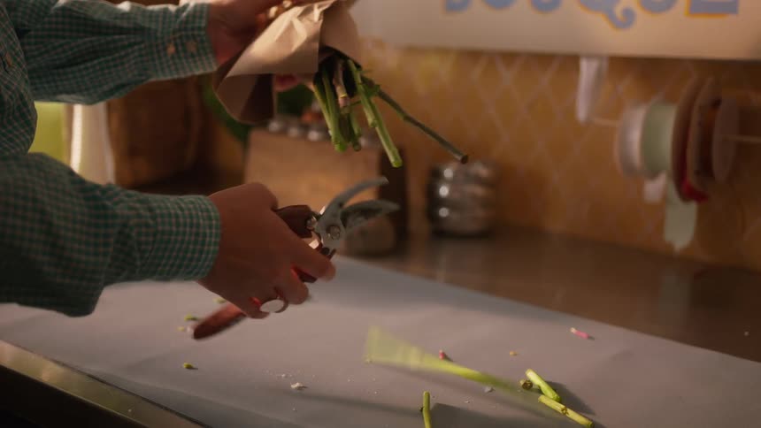 A florist cutting flowers in a room