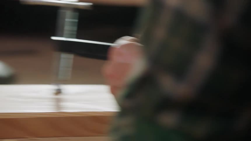 A person working on wood with a file