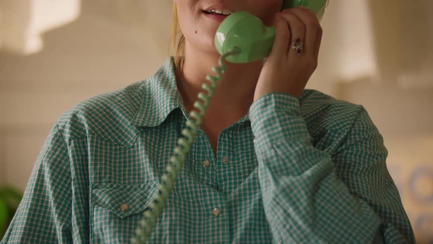 Woman answers a telephone on the counter