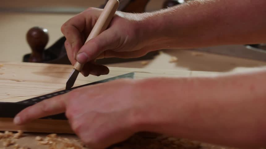 Precise markings being made on wood using a marking knife and ruler
