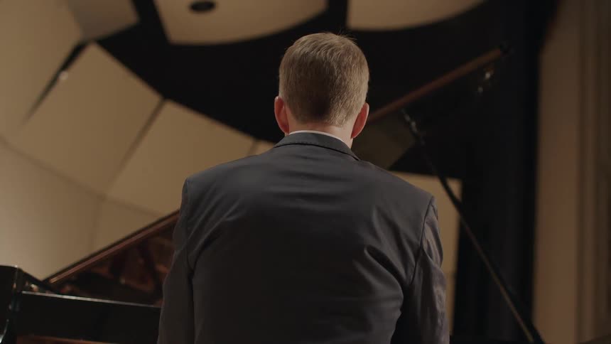 Man plays a piano on stage