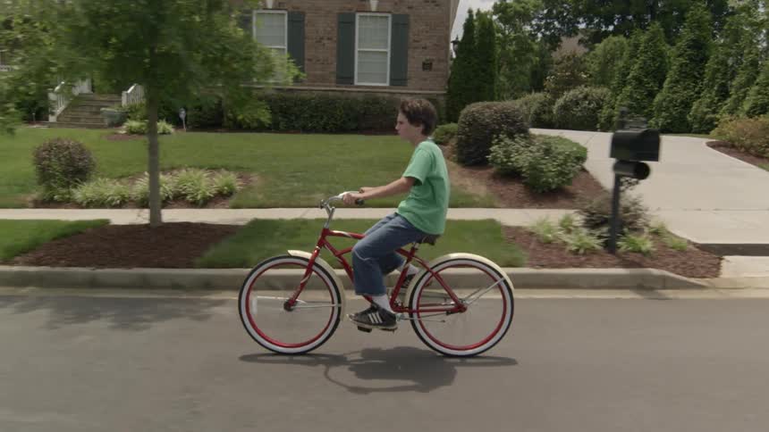 A boy rides a bicycle in a neighborhood