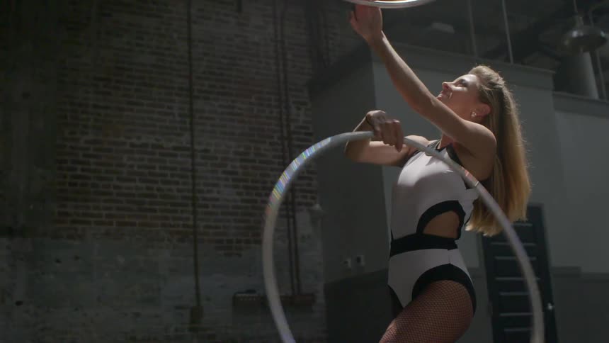 A woman spins hula hoops around her