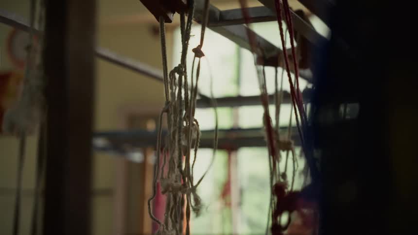 Threads hanging and intertwined on traditional loom frame