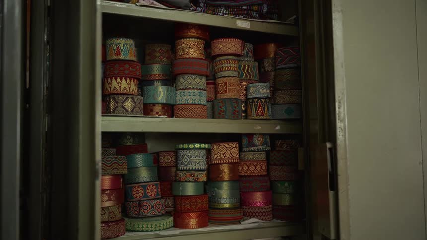 Colorful trim rolls arranged on cabinet shelves