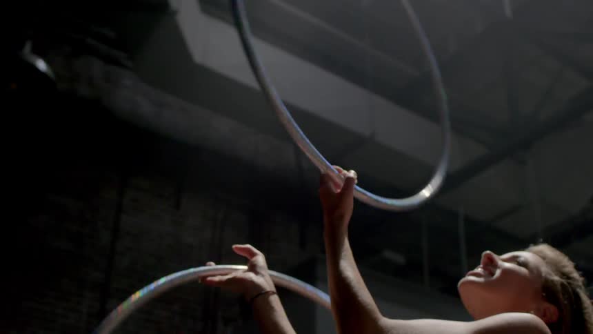 A woman twirls two hula hoops in her hands