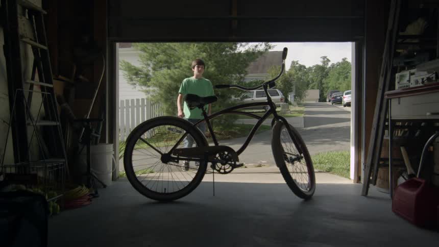 A garage door opens to reveal a bicycle
