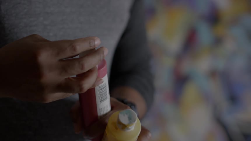 A man opens a bottle of paint