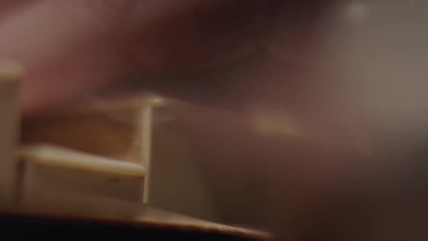 Person pushing down a piano key