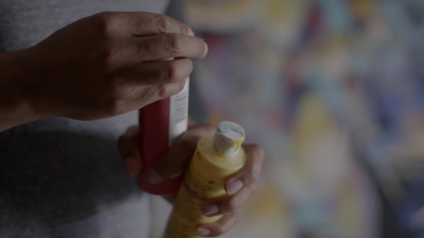 A man puts a lid on a bottle of paint