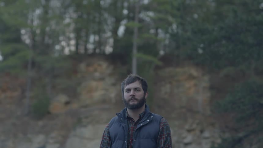 Man standing still and staring out in the wilderness