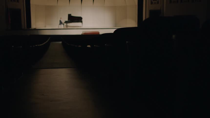 Man plays a piano on stage