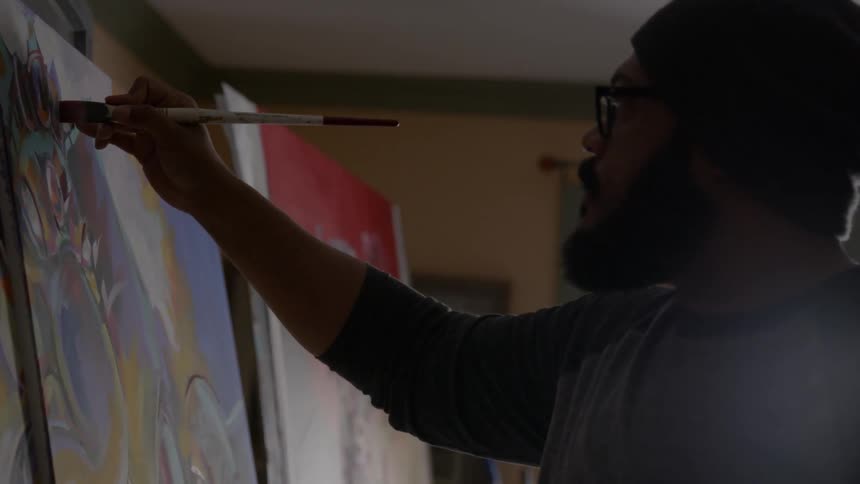 A man paints on a canvas