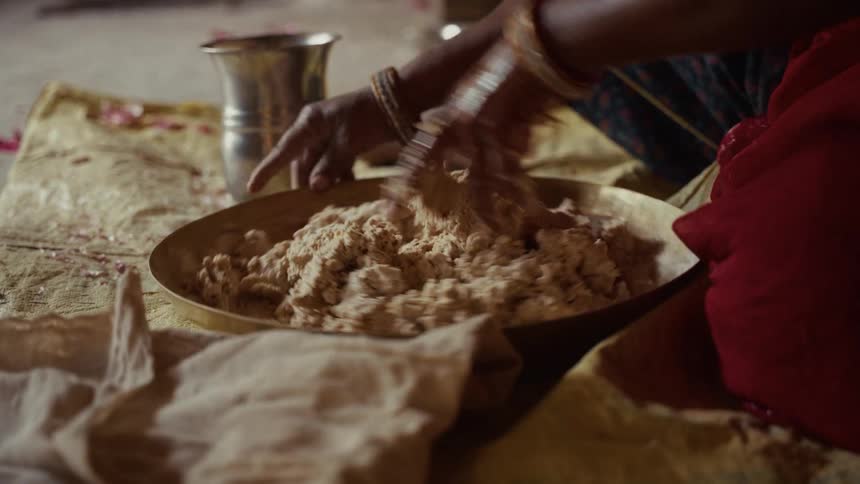 A woman kneads dough in a bowl